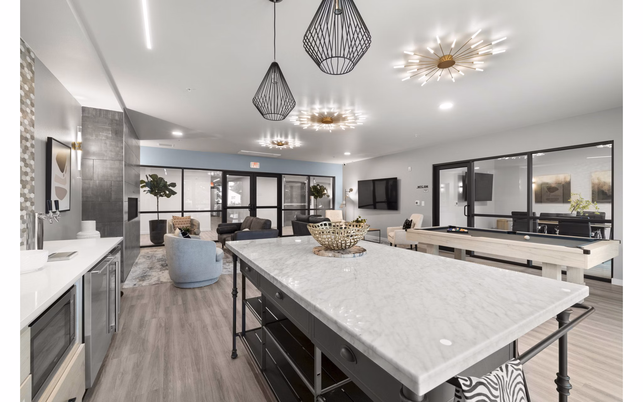 Clubhouse game room featuring pool table and modern seating at The Oliveen Apartments
