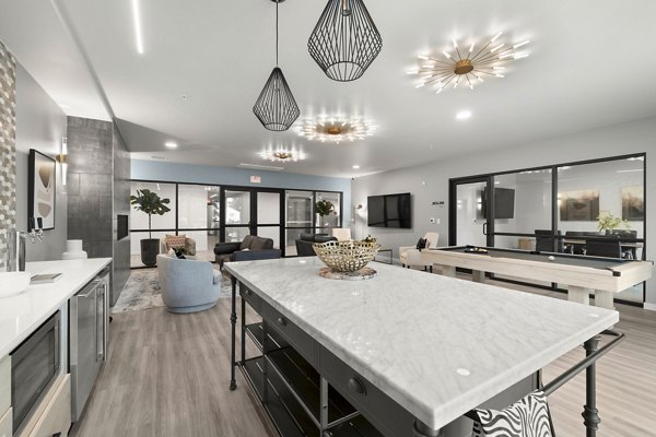 Clubhouse game room featuring pool table and modern seating at The Oliveen Apartments