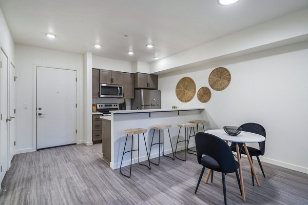 Dining room featuring elegant furnishings and natural lighting at The Oliveen Apartments