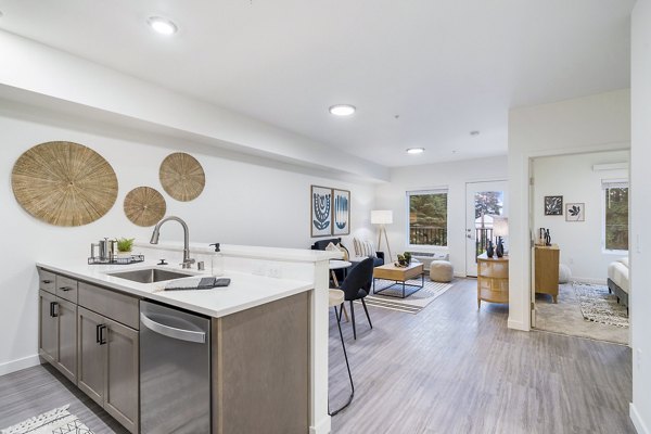 Modern kitchen with stainless steel appliances at The Oliveen Apartments in luxury Greystar community