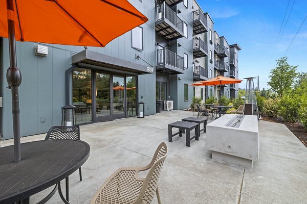 Outdoor patio with cozy fire pit at The Oliveen Apartments