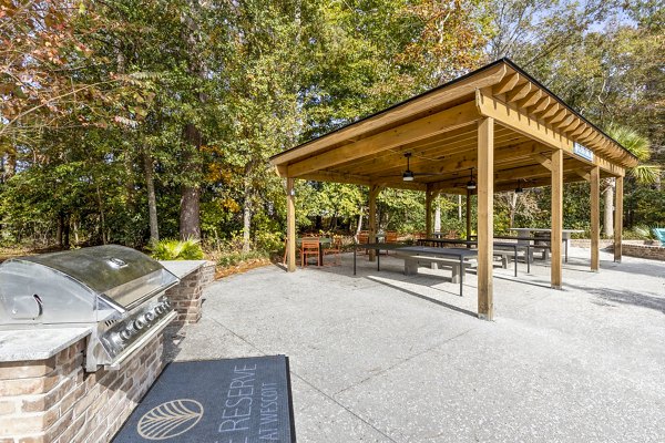 Grill area with outdoor seating on the patio at The Reserve at Wescott Apartments