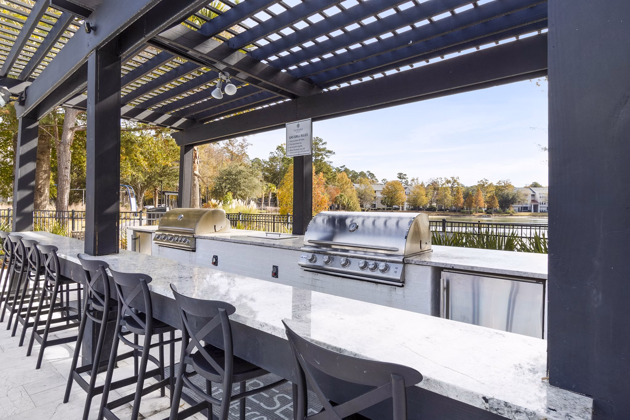 Grill area with seating on patio at The Reserve at Wescott Apartments