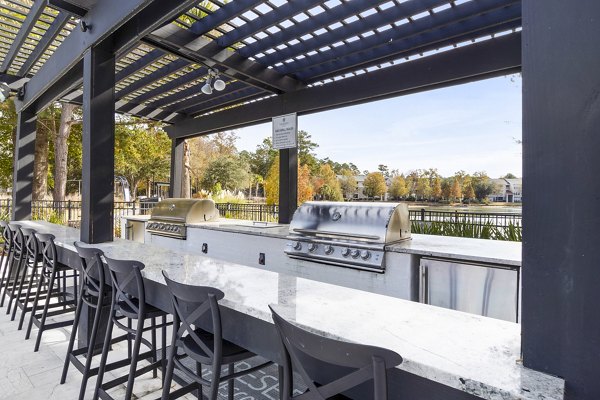 Grill area with seating on patio at The Reserve at Wescott Apartments