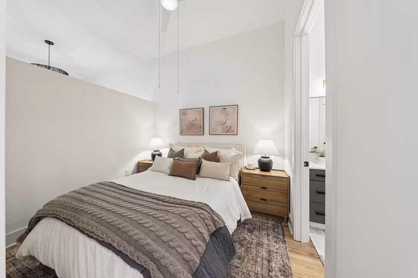Bedroom with modern decor and large windows at The Boulevard at Grant Park Apartments