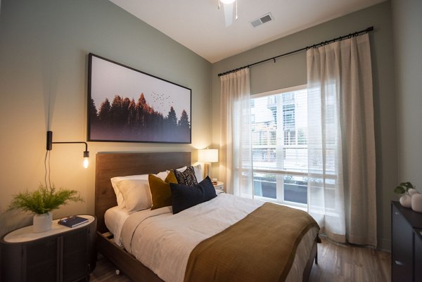 Bedroom with modern decor and large windows at The Boulevard at Grant Park Apartments