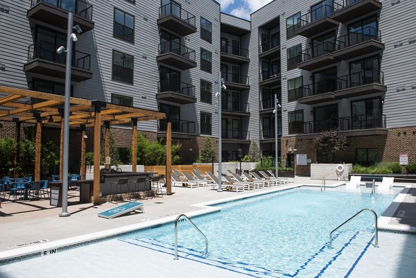Sunlit outdoor pool at The Boulevard at Grant Park Apartments, offering luxury leisure for residents amidst lush surroundings