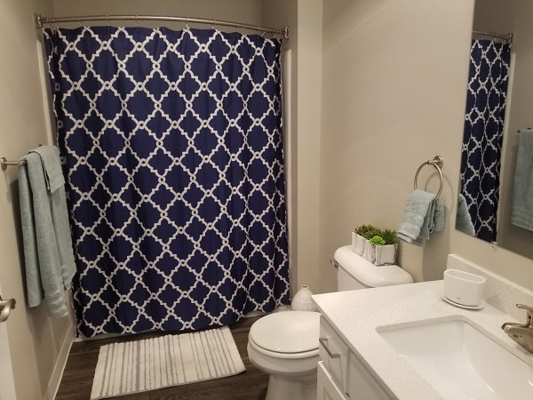 Bathroom featuring sleek fixtures and marble countertops at The Arden Apartments