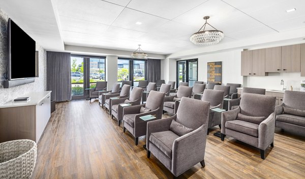 Clubhouse theater with plush seating and large screen at Avidor Omaha Apartments