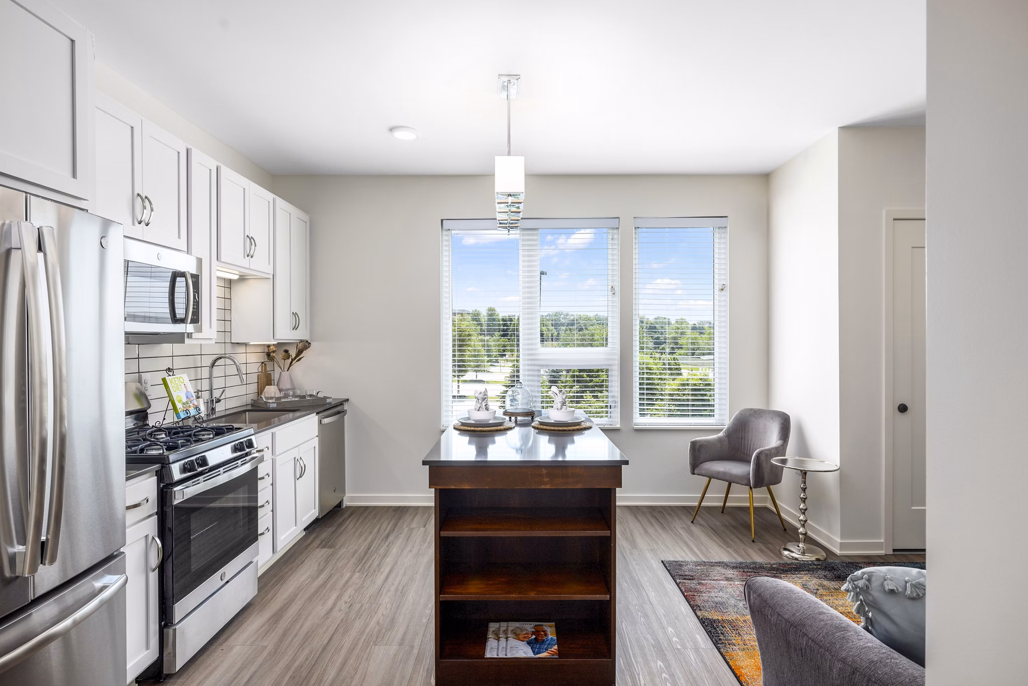 Sleek modern kitchen with island at Avidor Omaha Apartments featuring stainless steel appliances and quartz countertops