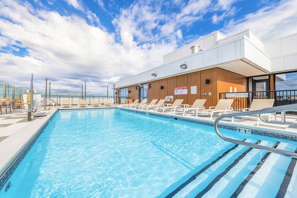 Outdoor pool area with chic lounge chairs at Avidor Evanston Apartments