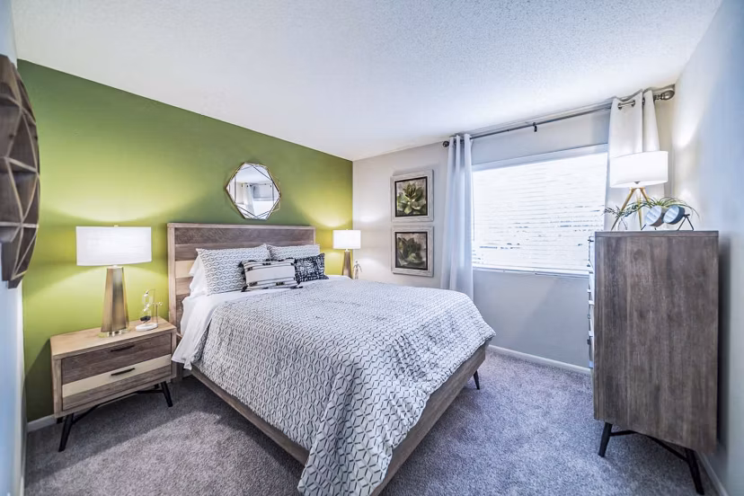 Bedroom with modern furnishings and ample natural light at Bay Cove Apartments Elegant design in a comfortable living space