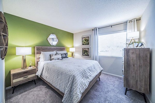 Bedroom with modern furnishings and ample natural light at Bay Cove Apartments Elegant design in a comfortable living space