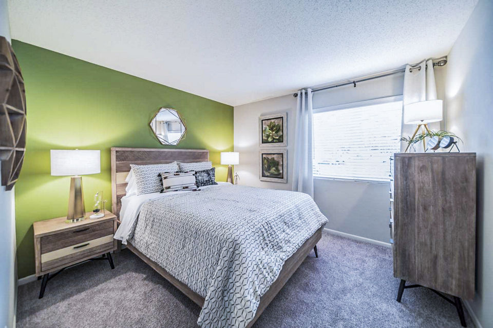 Bedroom with modern furnishings and ample natural light at Bay Cove Apartments Elegant design in a comfortable living space