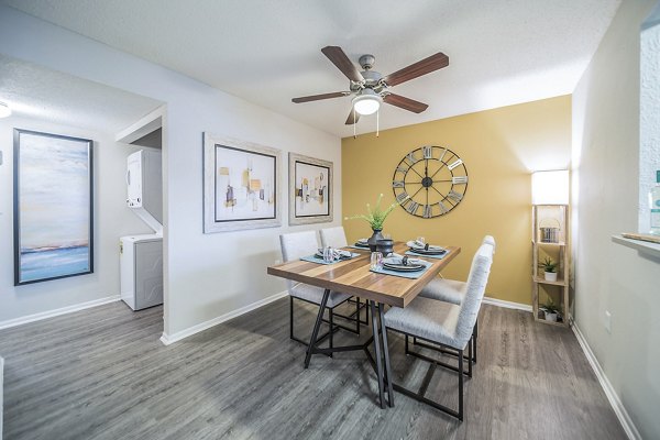 Dining room with contemporary design at Bay Cove Apartments featuring elegant lighting and sleek furnishings