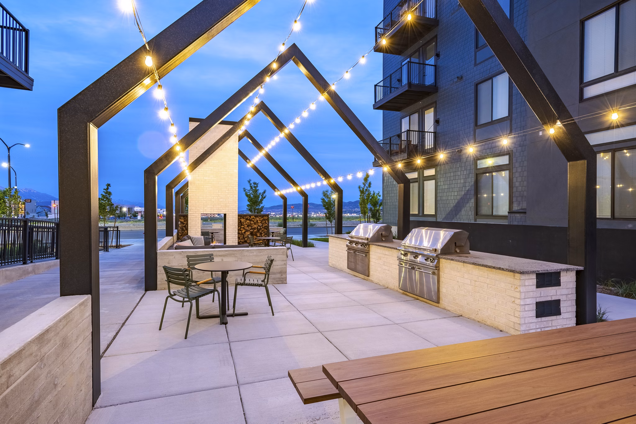 Grill area with modern seating and fire pit at Novel Daybreak Apartments