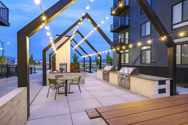 Grill area with modern seating and fire pit at Novel Daybreak Apartments