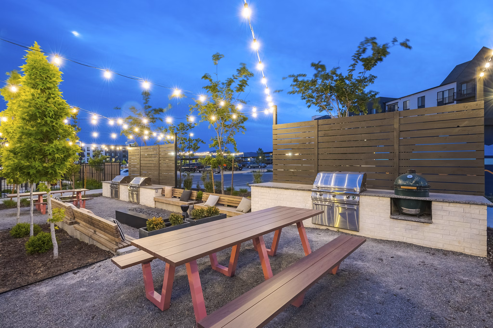 Outdoor grill area with modern seating and greenery at Novel Daybreak Apartments