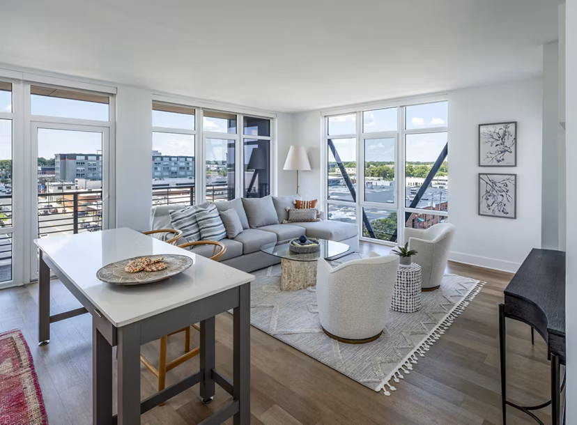 Spacious living room with modern furnishings in Otis Apartments, providing luxury living with ample natural light and elegant design elements