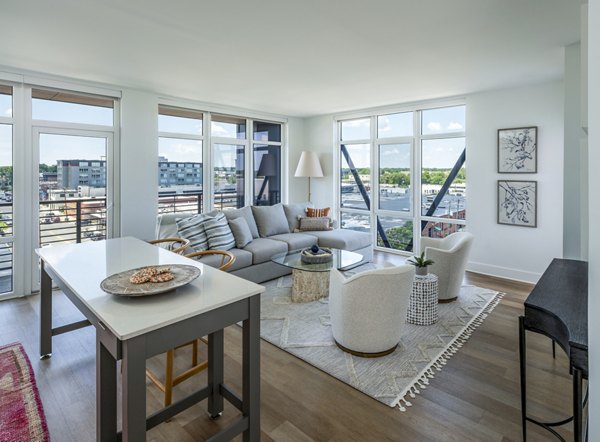 Spacious living room with modern furnishings in Otis Apartments, providing luxury living with ample natural light and elegant design elements