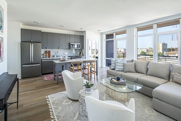Living room with modern furnishings and large windows in Otis Apartments, Greystar luxury apartments