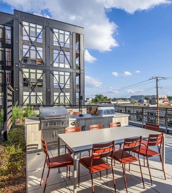Grill area and patio with seating at Otis Apartments