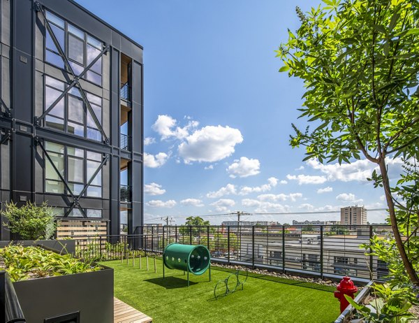 Fenced dog park featuring agility equipment at Otis Apartments, a pet-friendly community offering ample outdoor space
