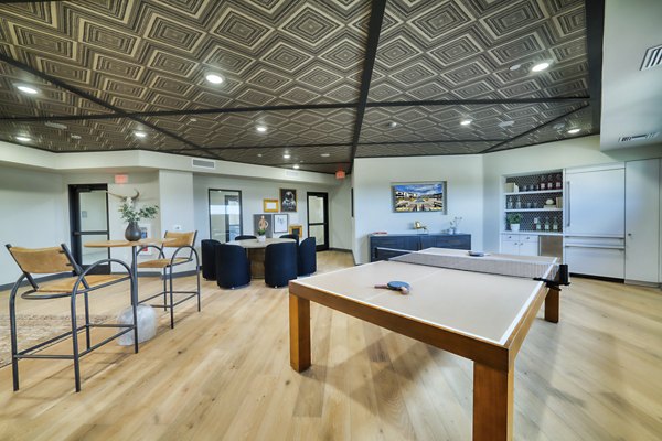 The Riley Apartments: Modern clubhouse with cozy seating and community dining area in luxury apartments