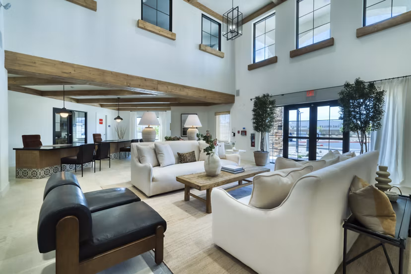 The Riley Apartments: Modern clubhouse featuring lounge seating and entertainment space in a luxury community