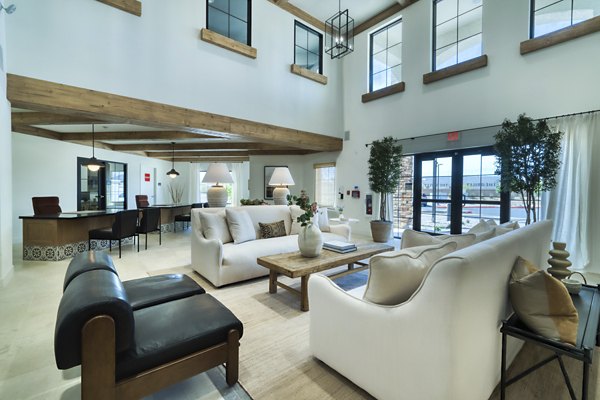 The Riley Apartments: Modern clubhouse featuring lounge seating and entertainment space in a luxury community