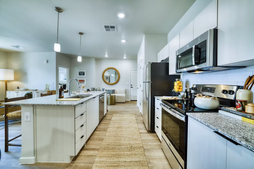 Modern kitchen with stainless steel appliances in The Riley Apartments