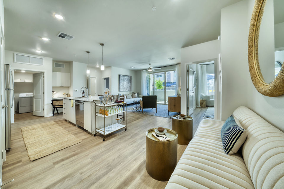 Spacious living room with modern decor and natural light at The Riley Apartments
