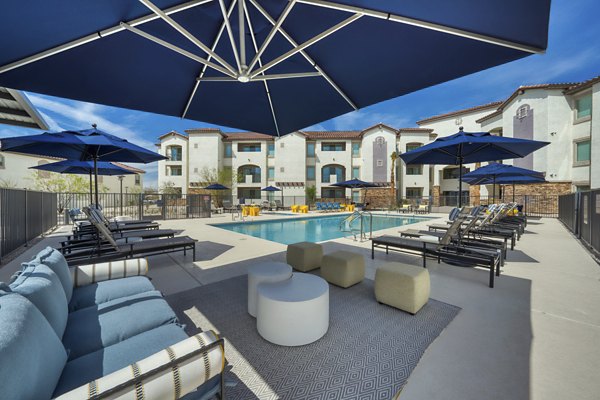 Luxurious rooftop pool with sparkling water and sun loungers at The Riley Apartments, offering serene relaxation in a modern urban setting