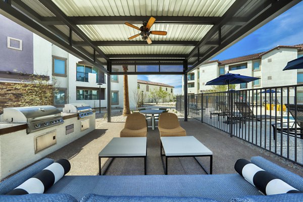 Outdoor grill area with modern seating at The Riley Apartments, offering a luxury cooking experience for residents