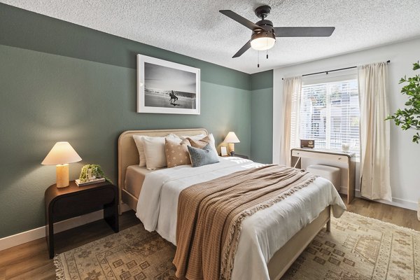 Cozy bedroom featuring modern decor and large windows at Madera Ridge Apartments, Greystar luxury living in a serene setting