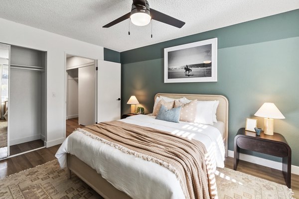 Luxurious bedroom with plush bedding and large windows at Madera Ridge Apartments
