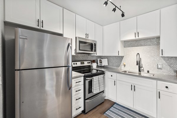 Modern kitchen with stainless steel appliances and granite countertops at Madera Ridge Apartments
