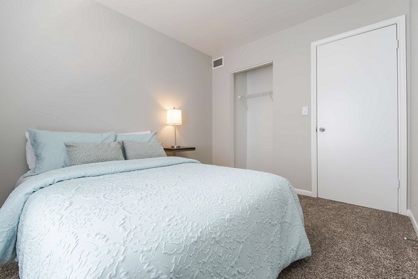 Cozy bedroom with plush bedding and natural light in Parcside Townhomes Apartments