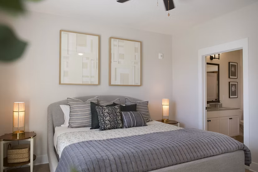 Cozy bedroom with modern decor and large windows in Novel University Place Apartments
