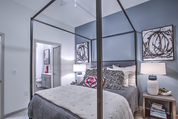 Cozy bedroom with large windows and modern decor at McKinney Terrace Apartments