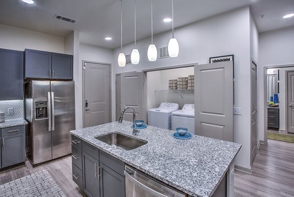 Spacious dining area with modern laundry room at McKinney Terrace Apartments, featuring contemporary design elements for luxury living