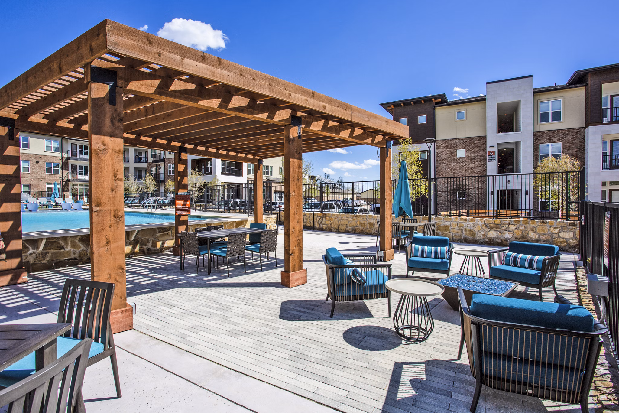 Patio with comfortable seating and lush landscaping at McKinney Terrace Apartments, offering serene outdoor relaxation spaces