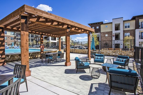 Patio with comfortable seating and lush landscaping at McKinney Terrace Apartments, offering serene outdoor relaxation spaces