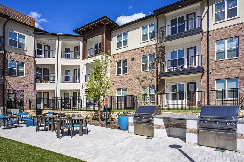 Outdoor grill area with seating at McKinney Terrace Apartments, perfect for hosting gatherings and enjoying luxury apartment living