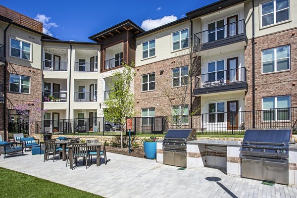 Outdoor grill area with seating at McKinney Terrace Apartments, perfect for hosting gatherings and enjoying luxury apartment living