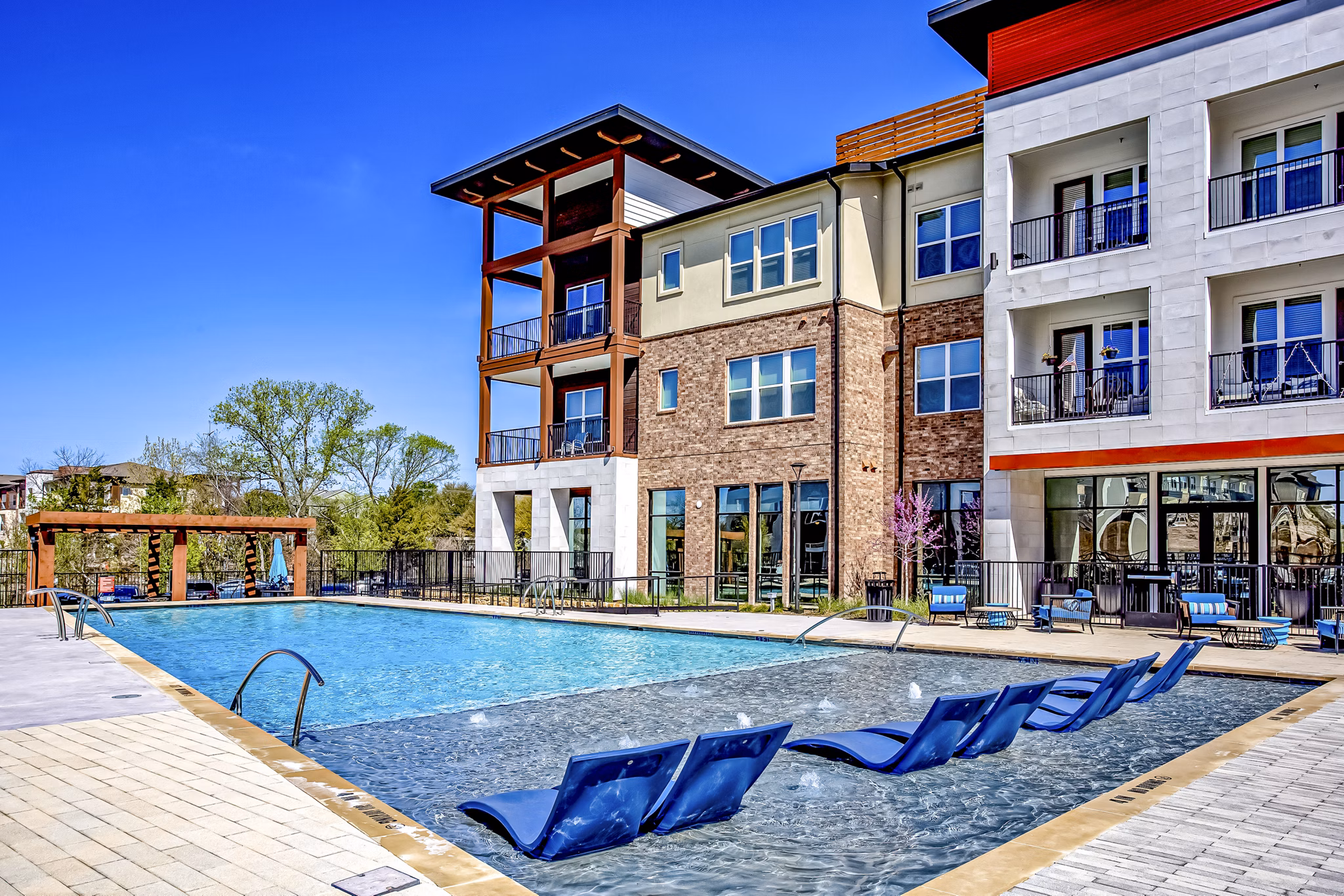 Resort-style pool with lounge chairs at McKinney Terrace Apartments