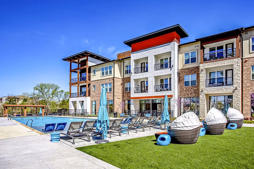Luxurious poolside view at McKinney Terrace Apartments with umbrella-shaded lounge chairs and sparkling water for relaxation