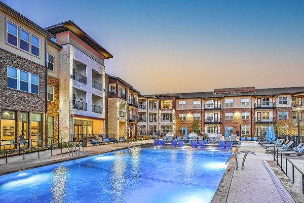 Outdoor swimming pool with lounge chairs at McKinney Terrace Apartments offering relaxation and leisure for residents