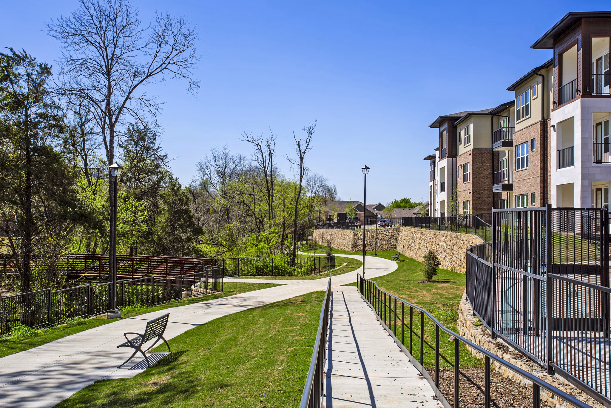 Walking trail surrounded by lush greenery at McKinney Terrace Apartments