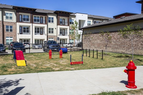 Dog park with agility equipment at McKinney Terrace Apartments, a pet-friendly community offering luxury living spaces